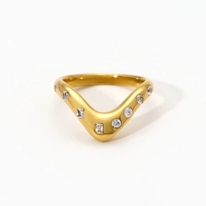 Close-up van gouden V-vormige roestvrijstalen ring met ronde en baguette zirkoon
