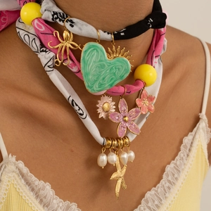 Silk scarf necklace with green marble heart pendant and gold flower charms on model