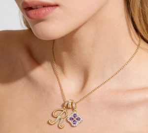 Détail du pendentif lettre R en zircons et fleur en pierre violette sur chaîne dorée