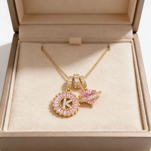 Collar bañado en oro con letra K de circonita y colgante de planeta corazón rosa