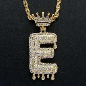 Detailopname van hiphop hanger letter E met kroon en druppel-effect in goudkleur