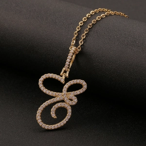 Macro shot of gold S-letter pendant with micro-paved cubic zirconia on black stand