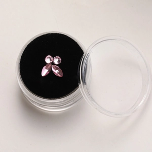 Macro view of four pink marquise and round rhinestones for tooth jewelry in a storage box