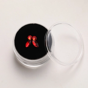 Detail view of red marquise and round cut crystal tooth gems in a transparent display case