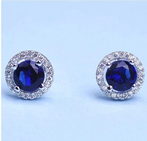 Détail de boucles d'oreilles en argent avec saphirs bleus ronds et entourage de zircons