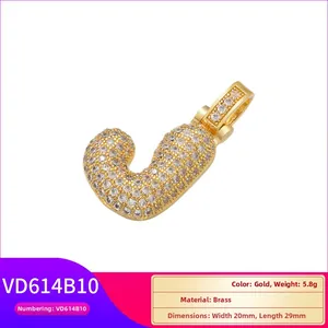 Vue macro du pendentif lettre J en laiton doré orné de zircons blancs micro-pavés