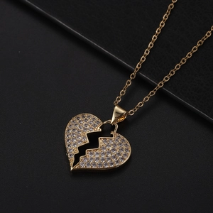 Dettaglio macro del ciondolo a cuore placcato oro 18K con pavé di zirconi su pelle nera
