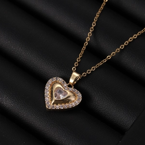 Dettaglio del ciondolo a cuore dorato con zircone centrale e incastonatura micro-pavé