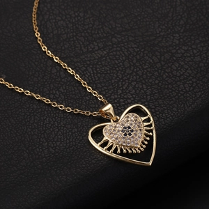Dettaglio del ciondolo a cuore in oro 18K con zirconi blu e bianchi su pelle nera