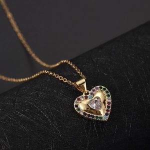 Macro di un ciondolo a cuore placcato oro 18K con zirconi colorati e catenina fine