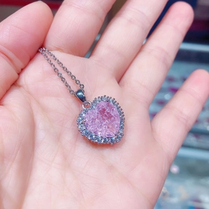 Nahaufnahme des rosa Herzanhängers mit Eiskristall-Textur und silberner Kette