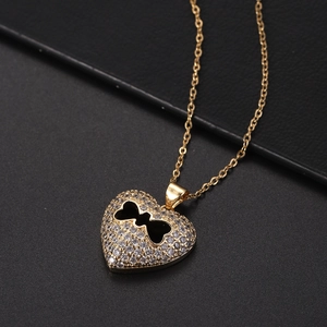 Dettaglio macro del ciondolo a cuore in oro 18K con design a osso cavo e pavé di zirconi
