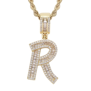 Macro shot of gold hip hop letter R pendant with sparkling zircon on a rope chain