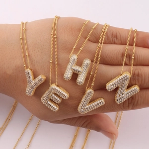 Golden bubble letter pendants with sparkling pave zircon stones on necklaces
