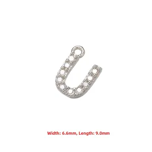 Macro detail of silver-plated letter U pendant with white cubic zirconia stones