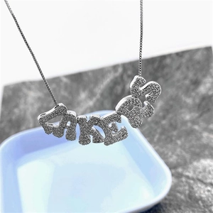 Detailed close-up of a silver-plated LAKERS alphabet pendant with micro-set zircon stones