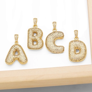 Makroaufnahme von 18K vergoldeten A-D Buchstabenanhängern mit Zirkonia-Besatz