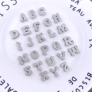 Macro view of 26 alphabet letter charms with micro-pave cubic zirconia for DIY jewelry
