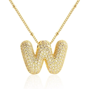 Dettaglio del ciondolo dorato lettera W con pavé di zirconi e catena a croce