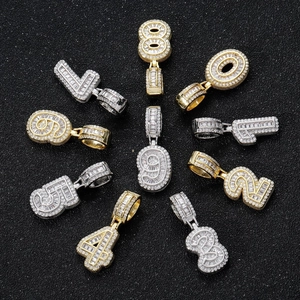 Macro view of iced out 0-9 number pendants with clear cubic zirconia in gold and silver