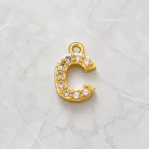 Detailed view of 18K gold letter C pendant micro-paved with sparkling cubic zirconia