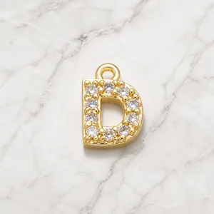 Macro shot of gold-plated letter D pendant with micro-paved white cubic zirconia