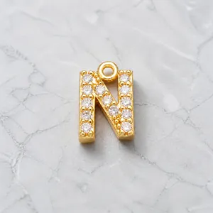 Macro shot of gold-plated letter N pendant with cubic zirconia inlay for jewelry making