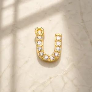 Detailed view of gold plated letter U pendant with cubic zirconia for jewelry making