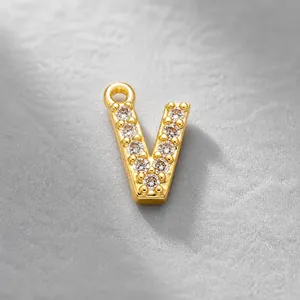 Detail view of a gold-plated letter V pendant paved with white zircon stones