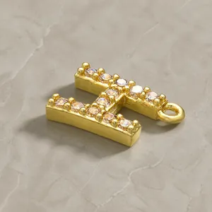 Macro shot of letter H pendant in gold plated copper with pave set white cubic zirconia