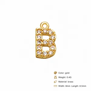 Macro shot of gold letter B charm with inlaid cubic zirconia and precise dimensions