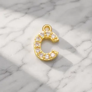 Detailed view of a gold-plated letter C pendant with sparkling cubic zirconia stones