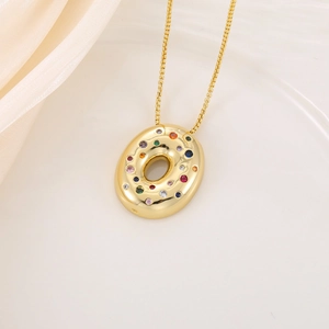 Détail du collier doré avec pendentif donut serti de zircons colorés sur soie