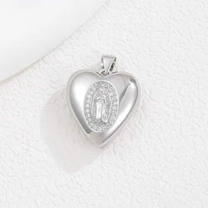 Makroaufnahme von Herz-Medaillon aus Silber mit religiösem Relief und Zirkonia-Steinen