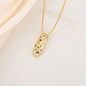 Détail du collier pendentif capsule dorée avec pierres de zircon colorées et chaîne