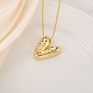 Vue macro du pendentif coeur doré avec zircone colorée et finition miroir poli brillant