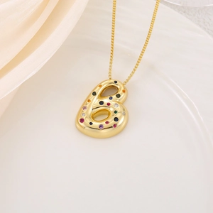 Pendentif lettre B dorée en relief avec zircons colorés sur tissu en soie