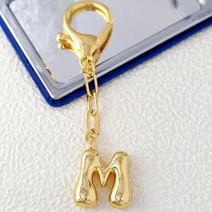 Polished 18K gold letter M bubble pendant keychain with spring lobster clasp detail