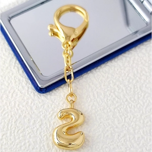 Detailed macro view of 18K gold-plated bubble number 2 pendant with lobster clasp keychain