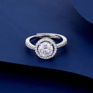 Macro detail of silver ring featuring halo-set round cubic zirconia and pavé diamond band