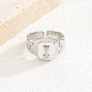 Makro-Detail von silbernem Buchstaben-I-Ring mit Zirkonia und Ziegeltextur-Band