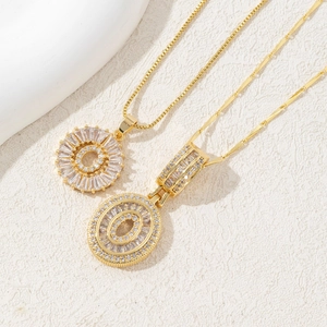 Detail of gold-plated necklaces with baguette-cut and round-cut cubic zirconia pendants