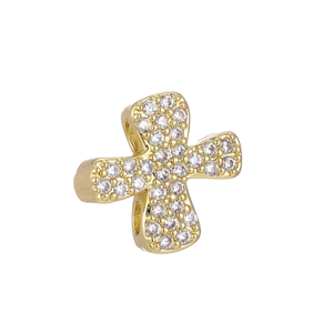 Macro detail of gold cross charm with micro-paved cubic zirconia stones and side hole