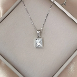Luxurious stainless steel necklace featuring a square zircon pendant on silk background