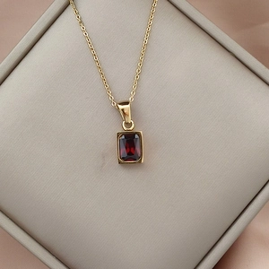 Close-up of a 18K gold stainless steel necklace with a red zircon rectangle pendant