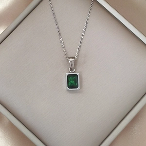 Close-up of luxury 18K silver-plated necklace with emerald green rectangular zircon pendant
