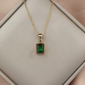 Close-up of 18K gold stainless steel chain with a rectangular green zircon pendant