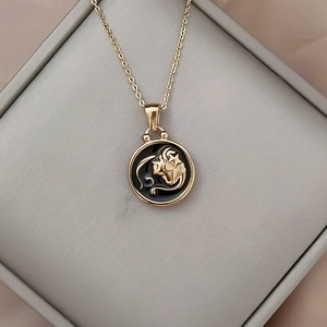 Close-up of golden zodiac necklace with lion pendant on black enamel in a jewelry box