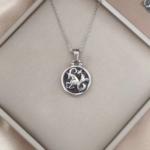 Macro shot of retro zodiac Capricorn pendant necklace in a premium silk gift box