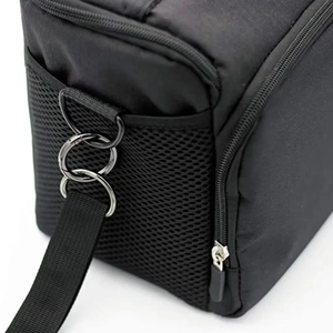 Close-up of black mesh pocket and triple metal ring connectors on a storage bag